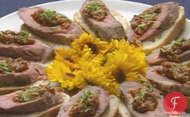 Loin de miel ars cu crustă de usturoi-piper cu Hash de roșii servit pe Crostini