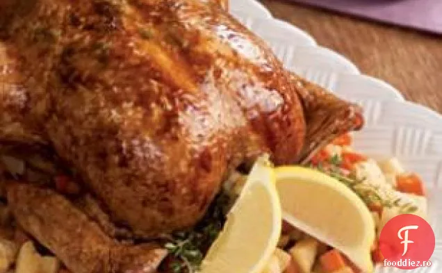 Pui de lămâie prăjită întreg pe un pat de legume