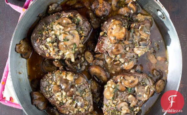 Fripturi proaspete de filet de vită acoperite cu ierburi cu sos de ciuperci