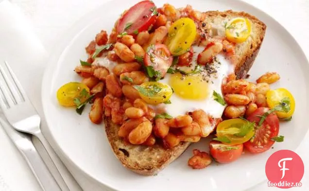 Ouă coapte și fasole pe pâine prăjită