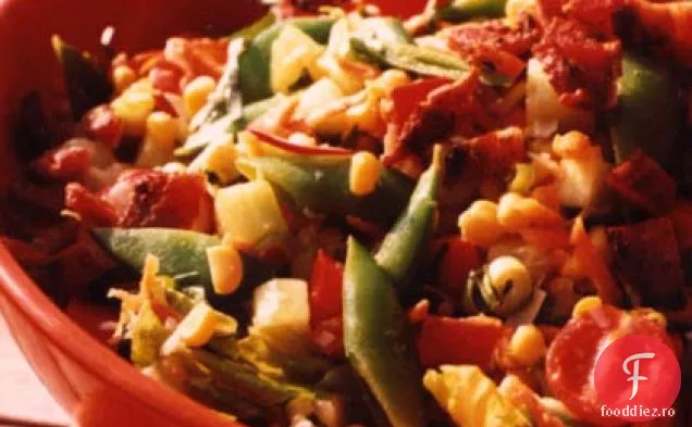 Tăiați salata cu porumb, mazăre și slănină